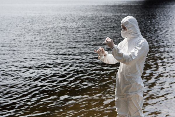 Científico recolectando muestras de agua en lago.