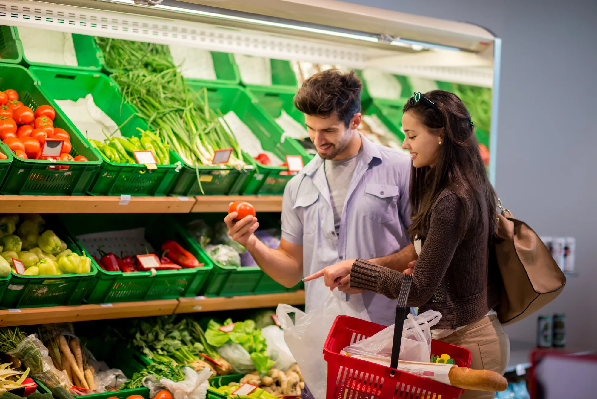 Pareja elige verduras en supermercado