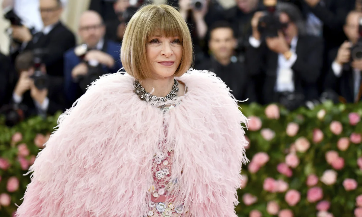 Mujer con vestido rosa y capa de plumas