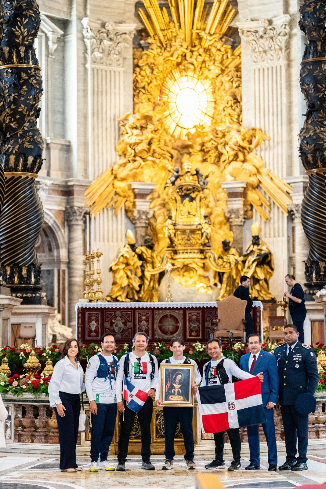 Personas posan frente a altar dorado.