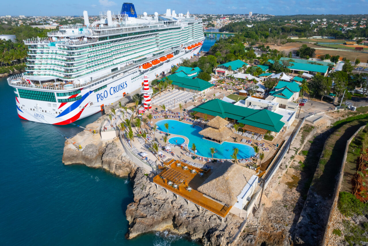 Crucero atracado junto a complejo turístico costero.