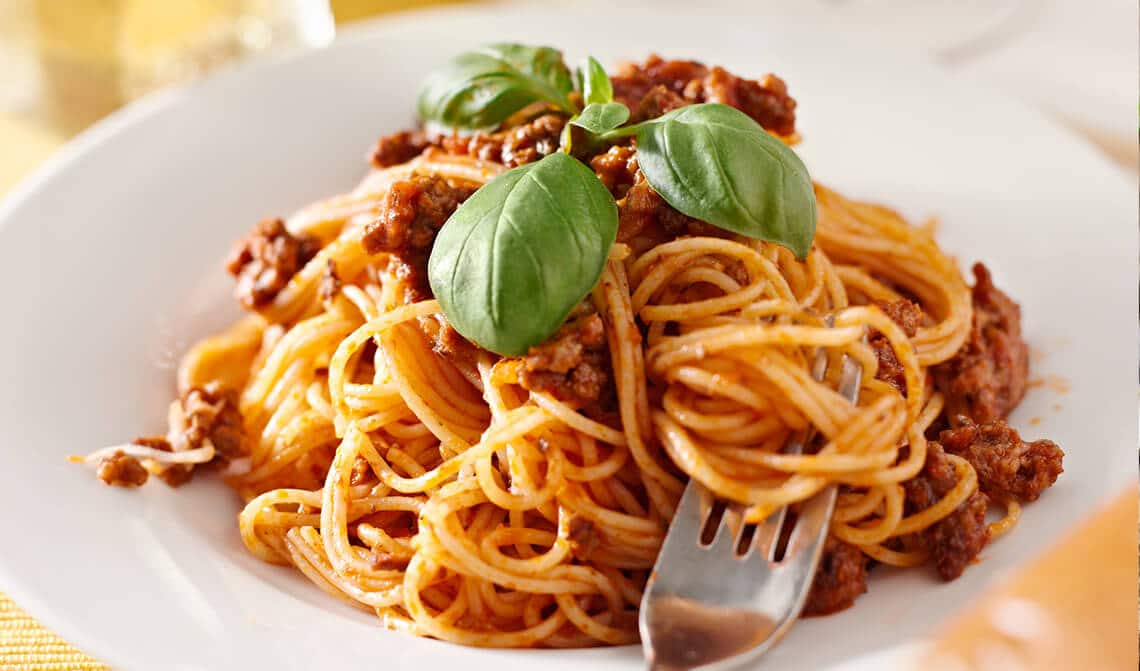 Plato de espaguetis con carne y albahaca