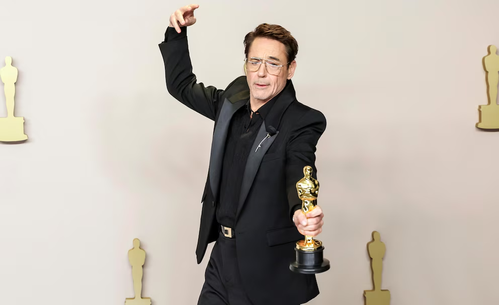 Persona con trofeo Oscar posando alegremente