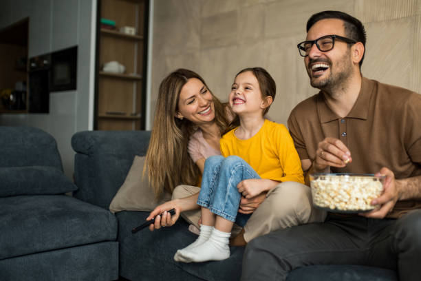 Familia feliz viendo televisión en casa.