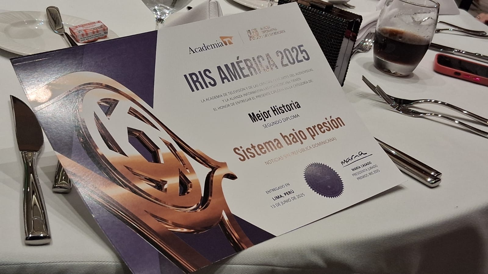 Diploma IRIS AMÉRICA 2025 sobre mesa