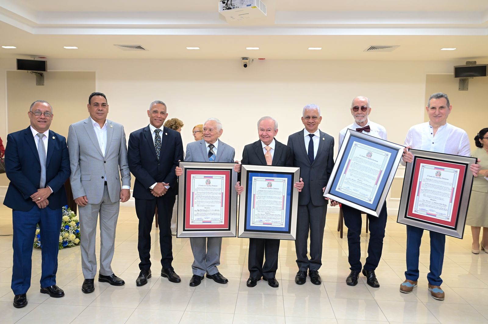Hombres en traje sosteniendo certificados en ceremonia