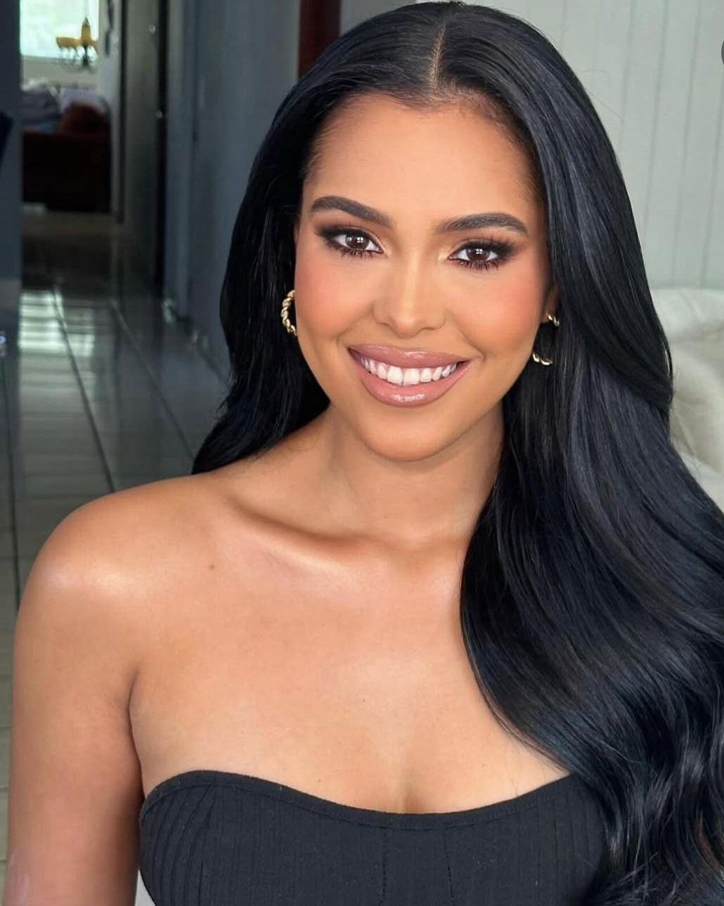 Mujer sonriendo, cabello largo, fondo interior.