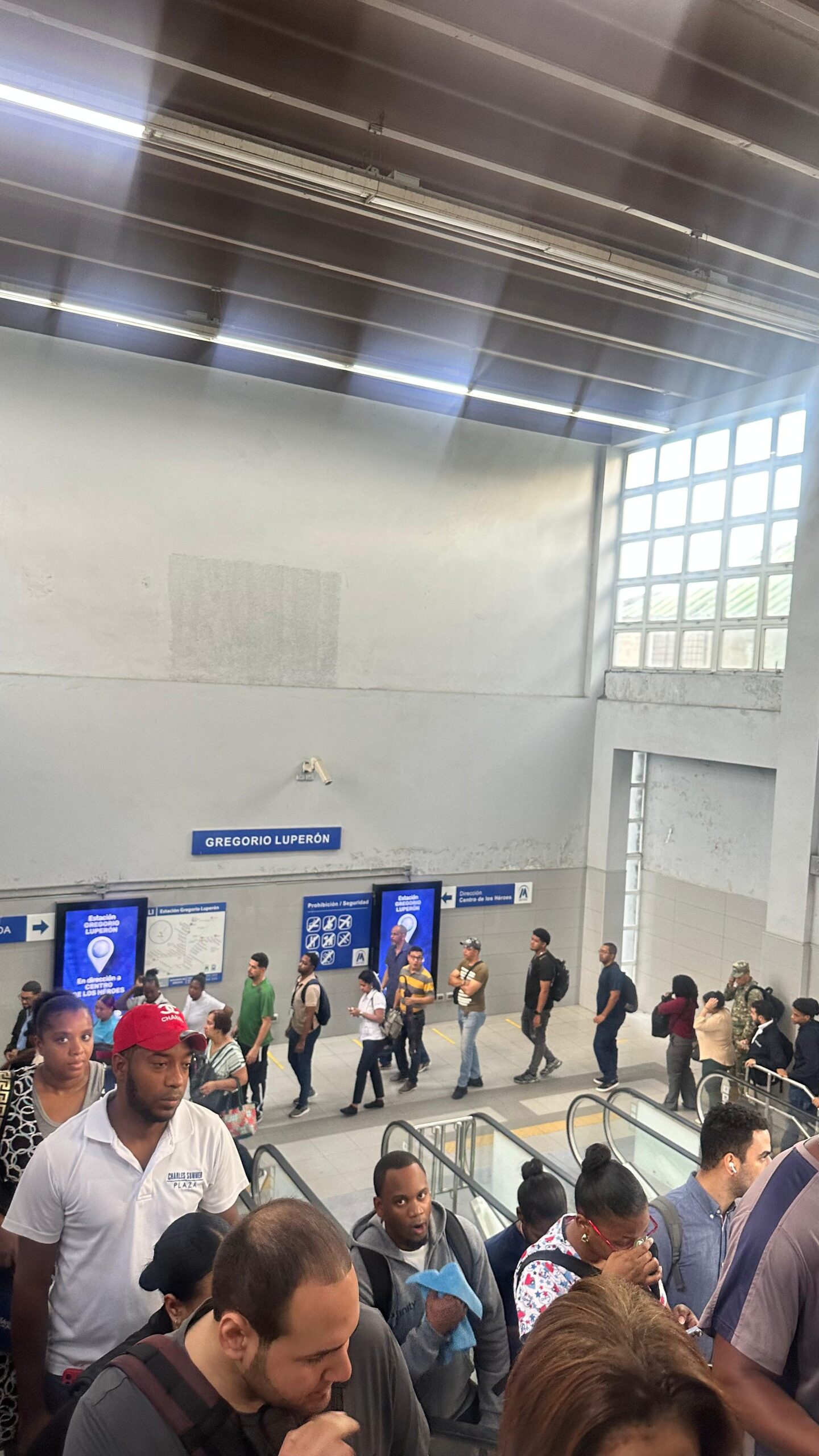Personas en estación Gregorio Luperón, escaleras mecánicas.