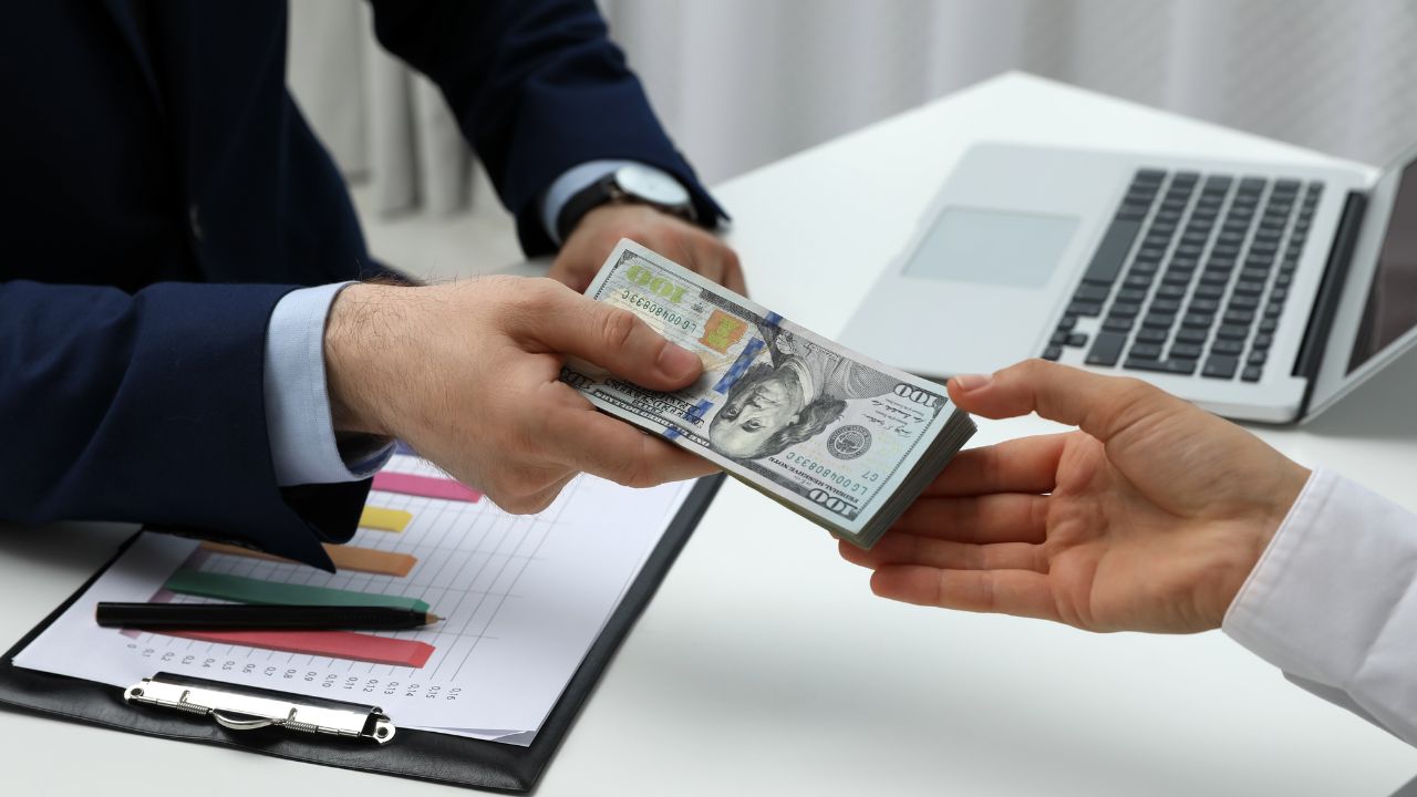 Intercambio de dinero entre dos personas en oficina