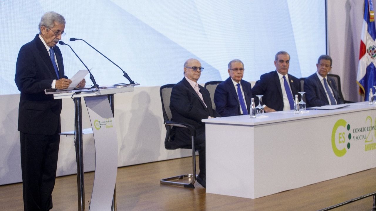 Hombres en evento oficial con bandera dominicana.