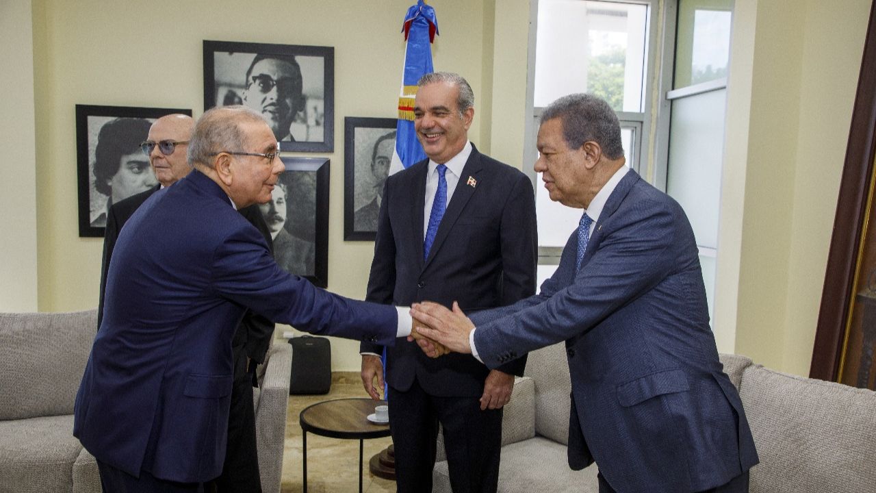 Hombres de traje estrechando manos en reunión formal
