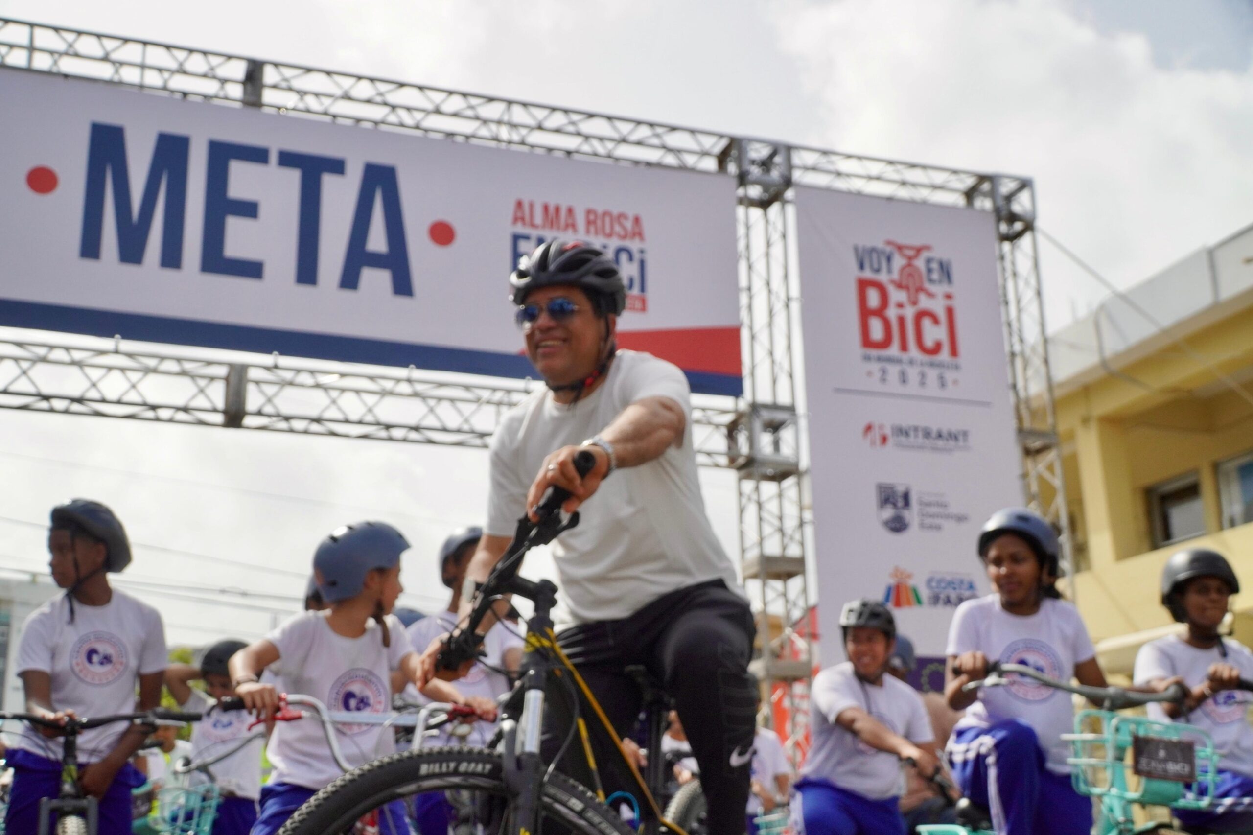 Ciclistas cruzan línea de meta en evento 'Voy en Bici'.