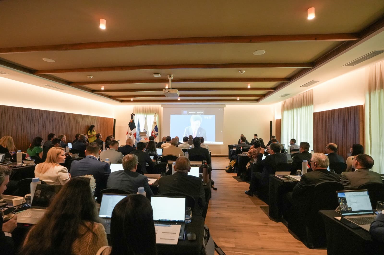 Conferencia con asistentes y proyección en pantalla.