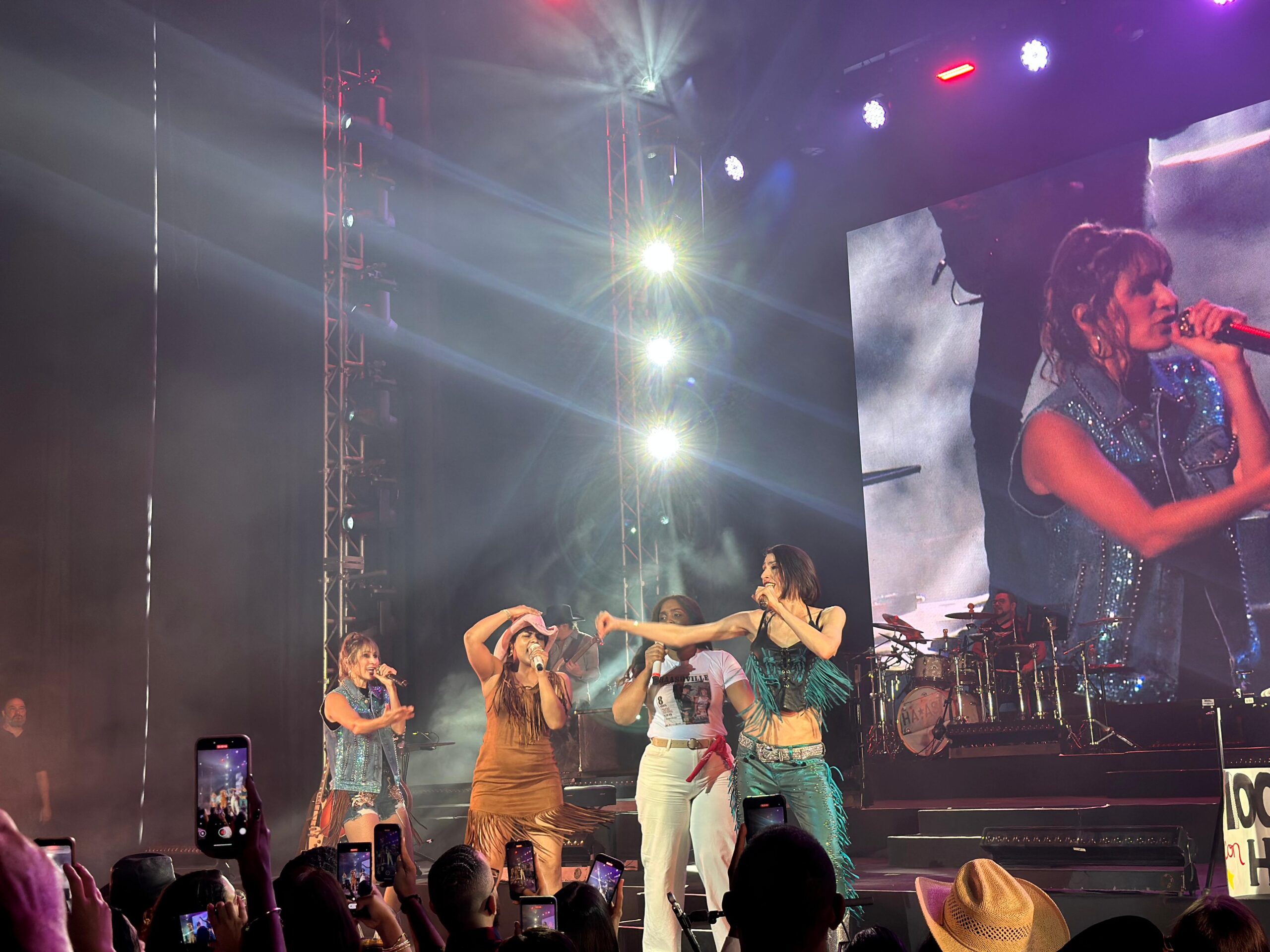 Concierto en vivo con luces y cantante en escenario.