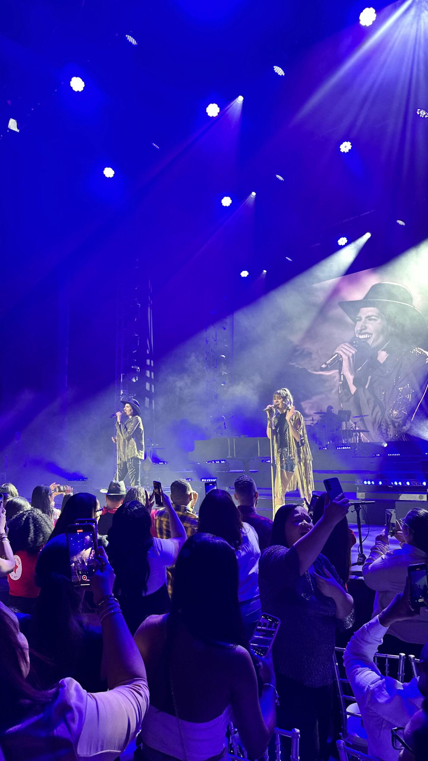 Concierto en vivo con cantantes y público entusiasta.