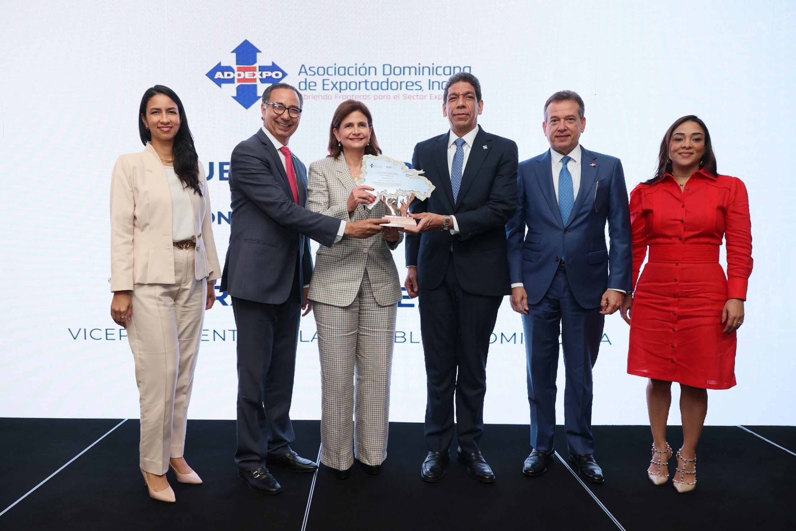 Entrega de premio a grupo de personas formales.