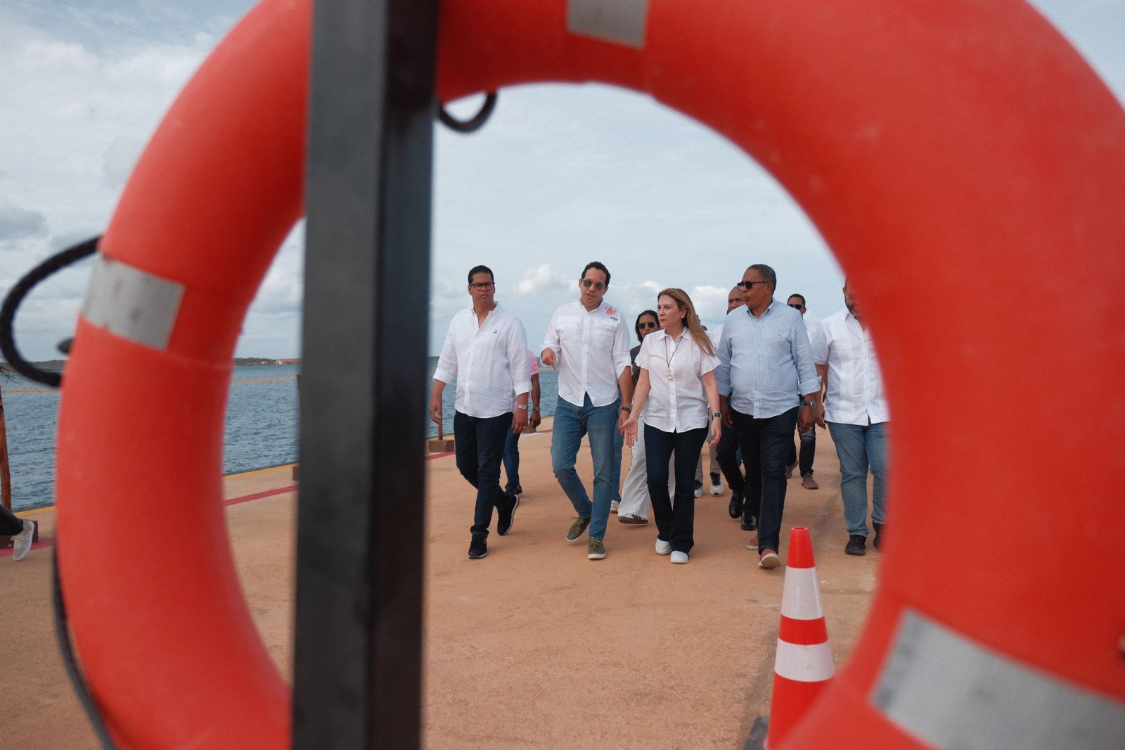 Grupo de personas caminando en muelle.