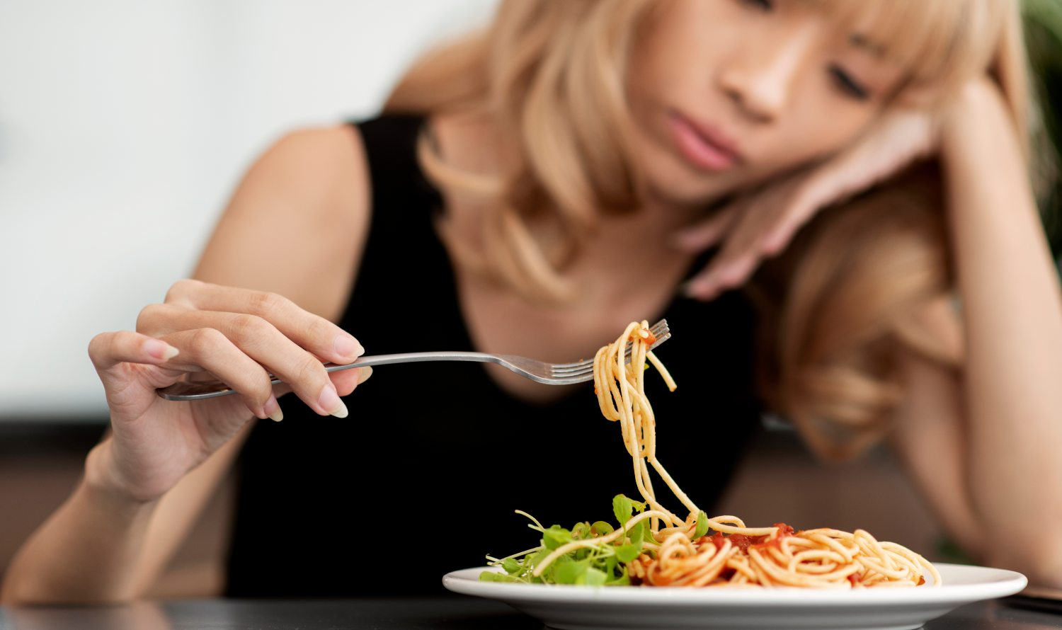 Persona comiendo espaguetis con tenedor
