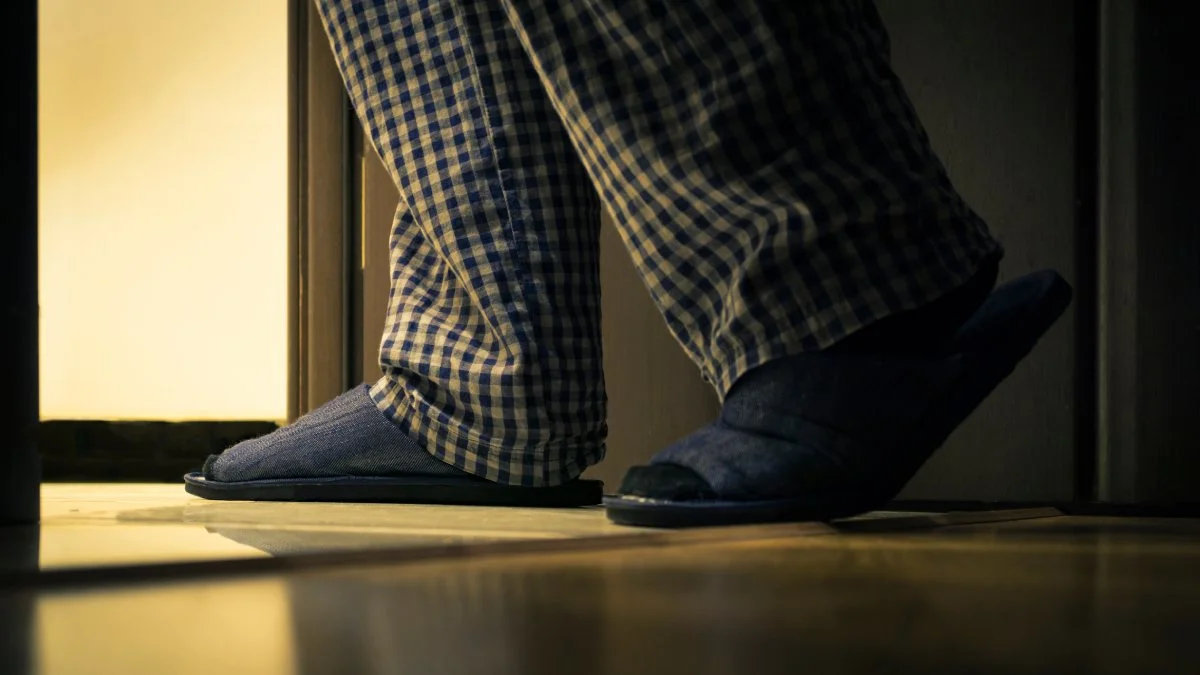 Persona en pijama camina con zapatillas en casa