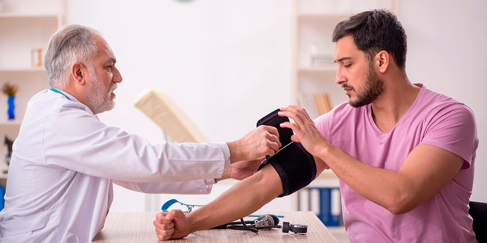 Médico mide tensión arterial a paciente joven