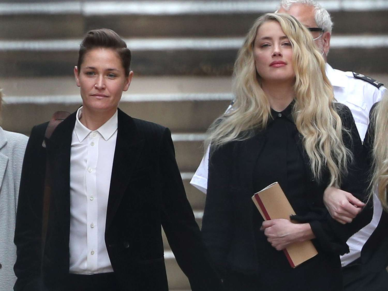 Dos personas caminando juntas con carpetas