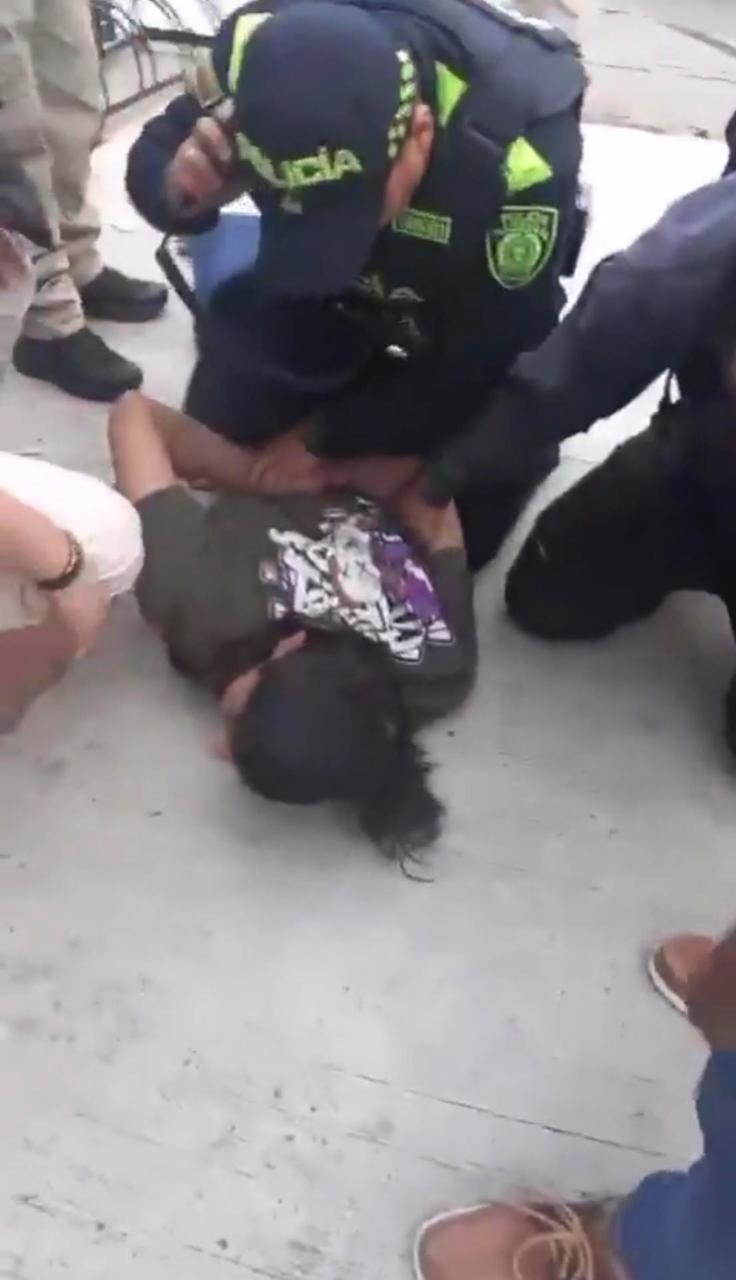 Agentes detienen a persona en el suelo