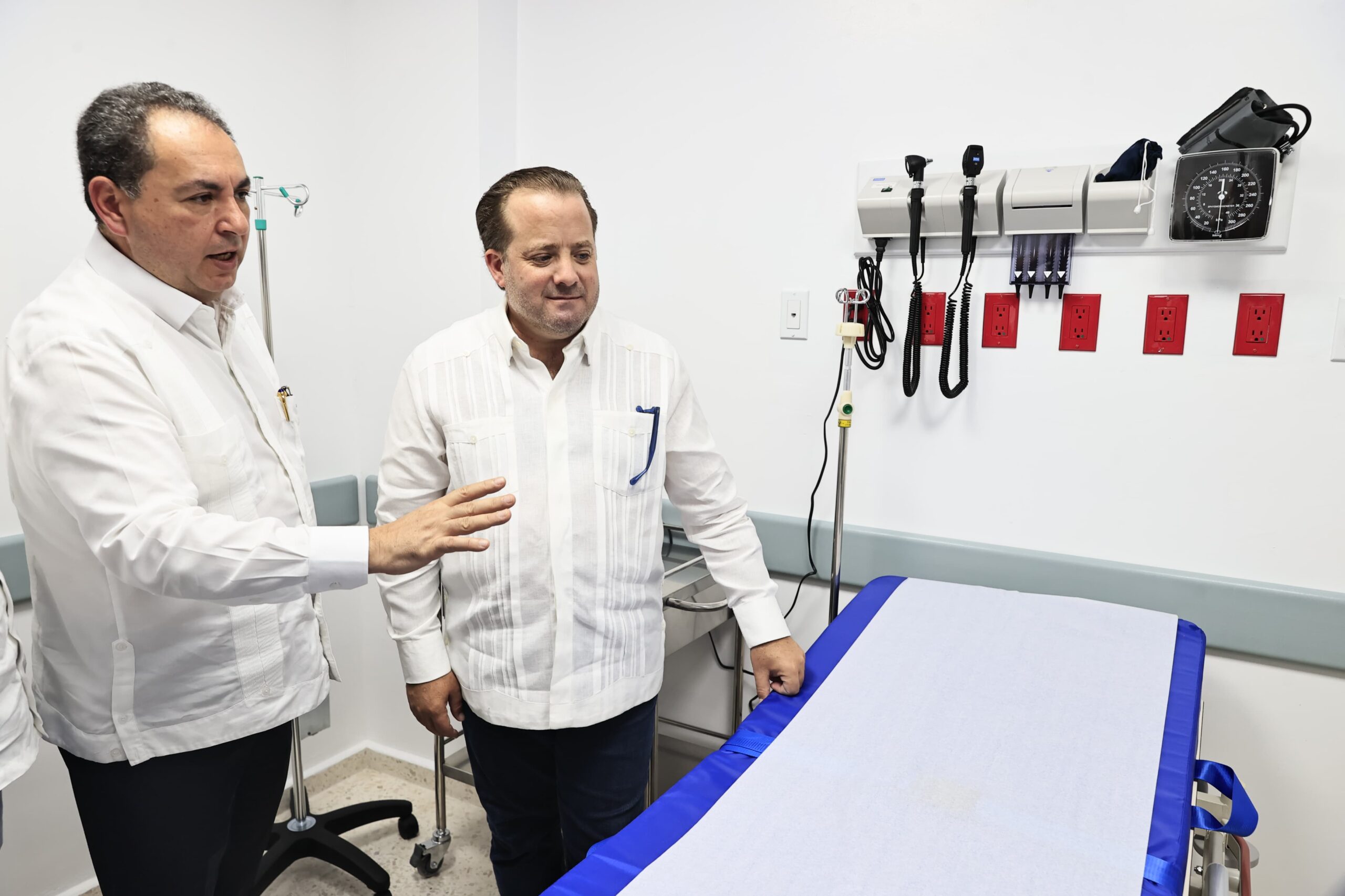Dos hombres conversan en un consultorio médico.