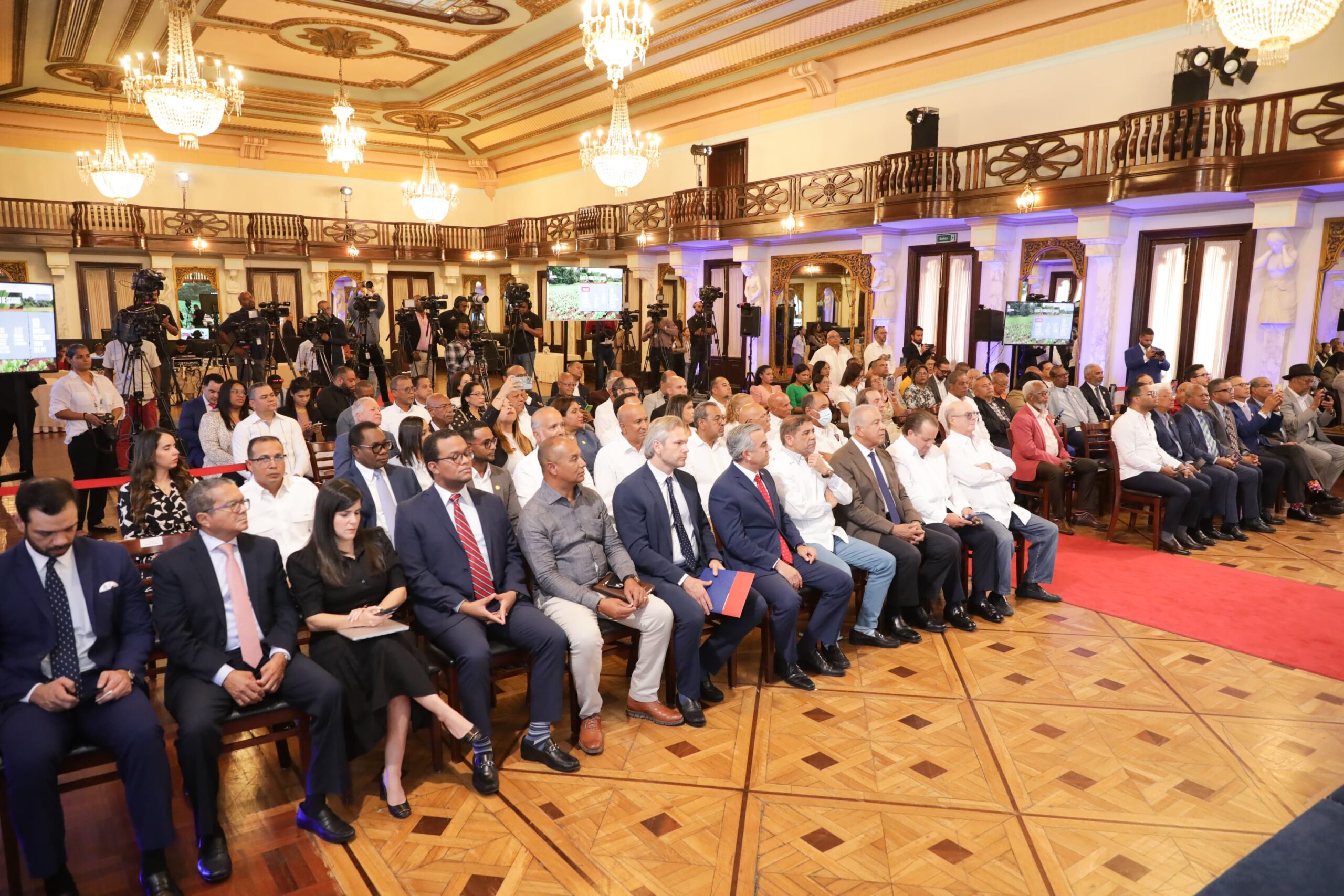 Evento formal en salón con público atento.