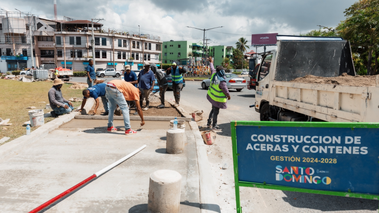 Trabajadores construyen aceras en Santo Domingo, 2024-2028.