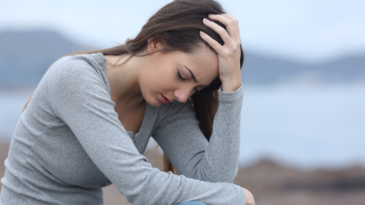 Mujer pensativa con la mano en la cabeza