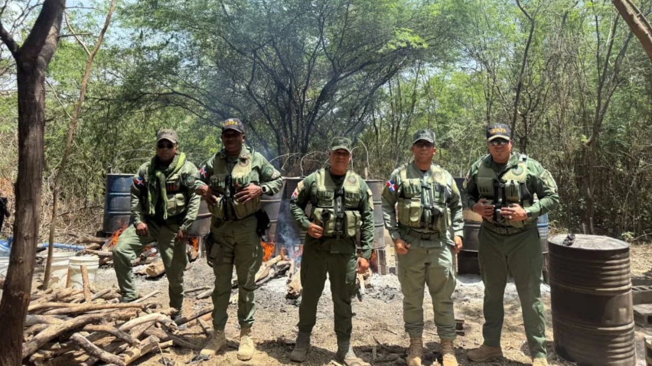 Cinco personas en uniforme militar en el bosque.