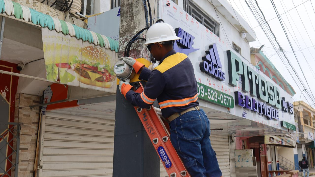 Electricista trabajando en poste de luz, con escalera.