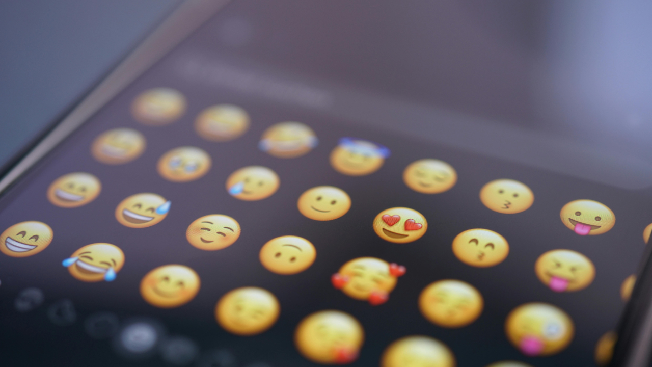 Pantalla de móvil con emoticonos variados.