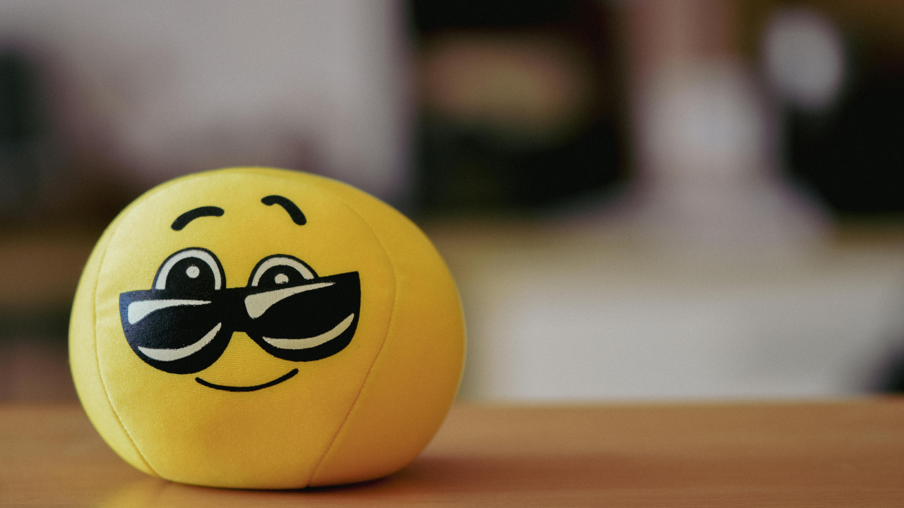 Pelota amarilla con cara de gafas sonriendo.