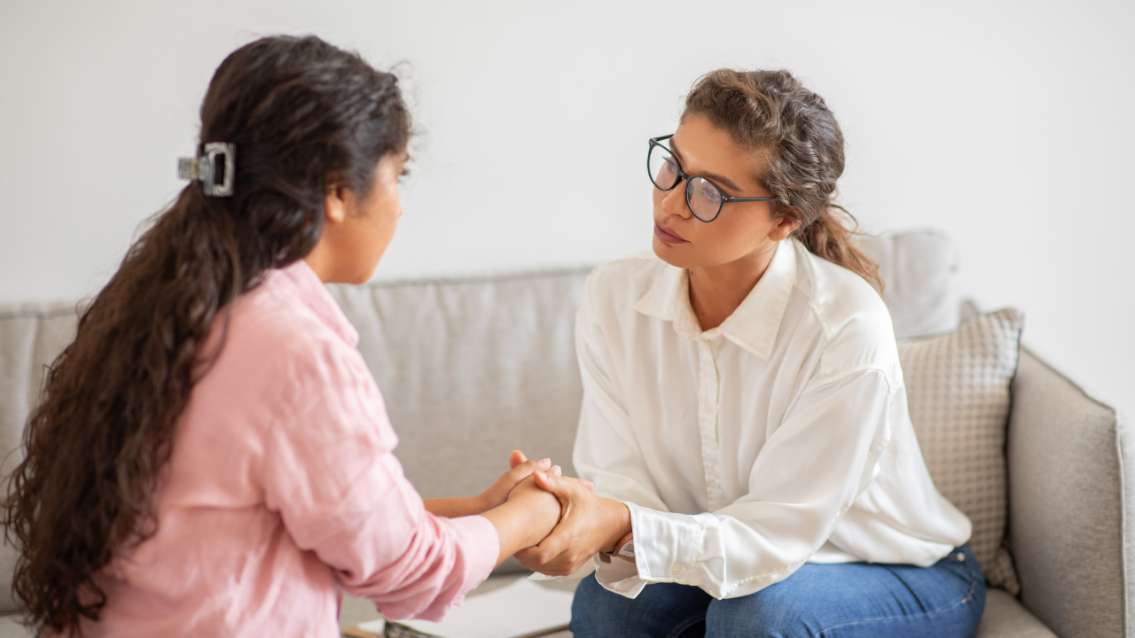 Dos mujeres conversan en un sofá