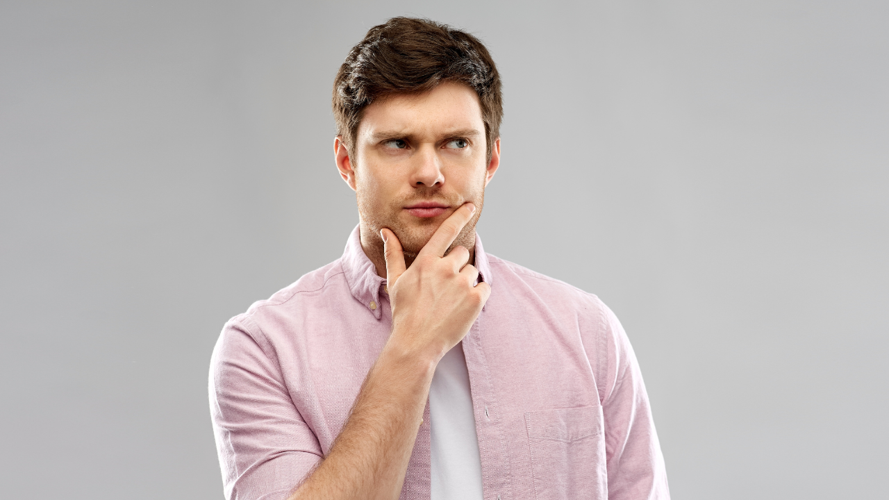 Hombre pensativo con camiseta rosa