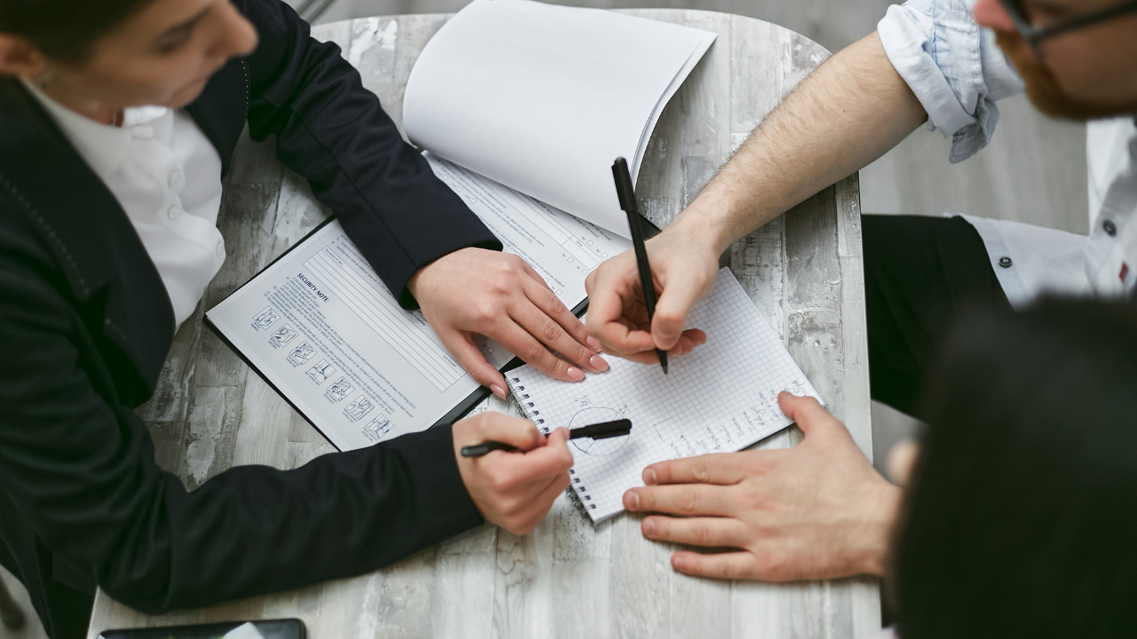 Personas escribiendo en documentos y blocs de notas