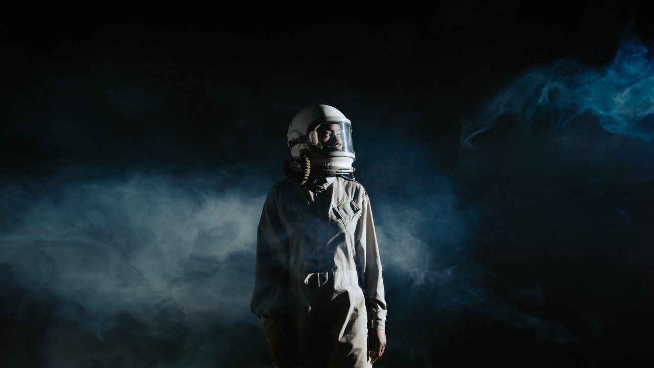 Astronauta con casco espacial en humo oscuro