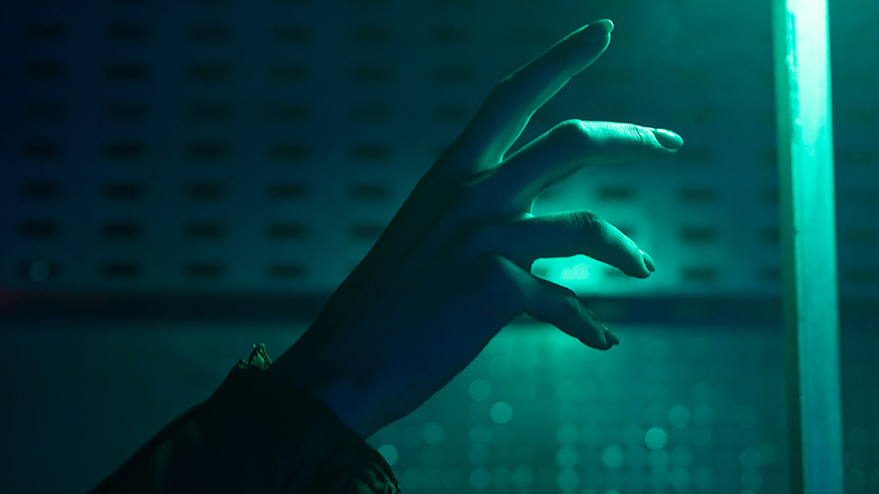 Mano iluminada en tono verde oscuro