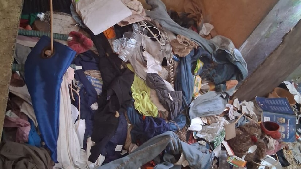 Habitación desordenada llena de ropa y objetos variados.