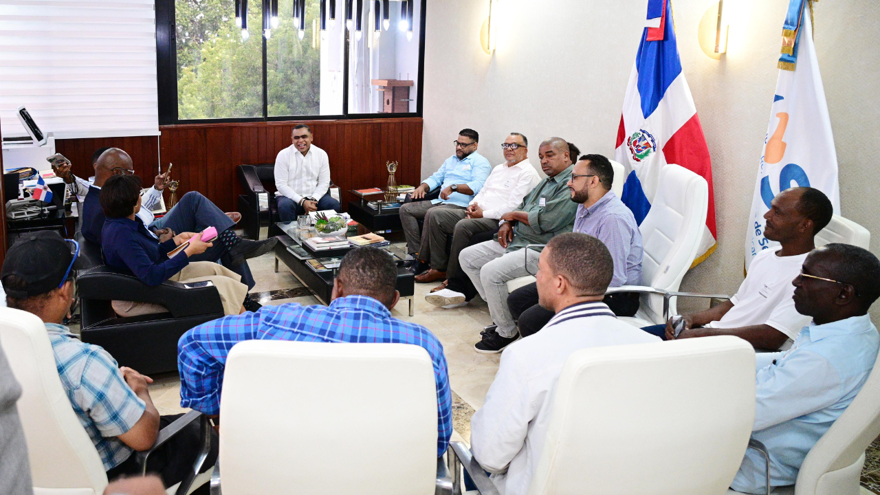 Reunión de hombres alrededor de una mesa en oficina.