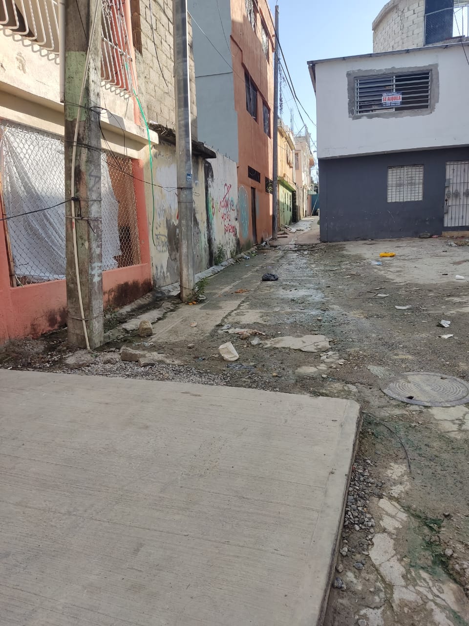 Callejón estrecho con edificios y grafitis.