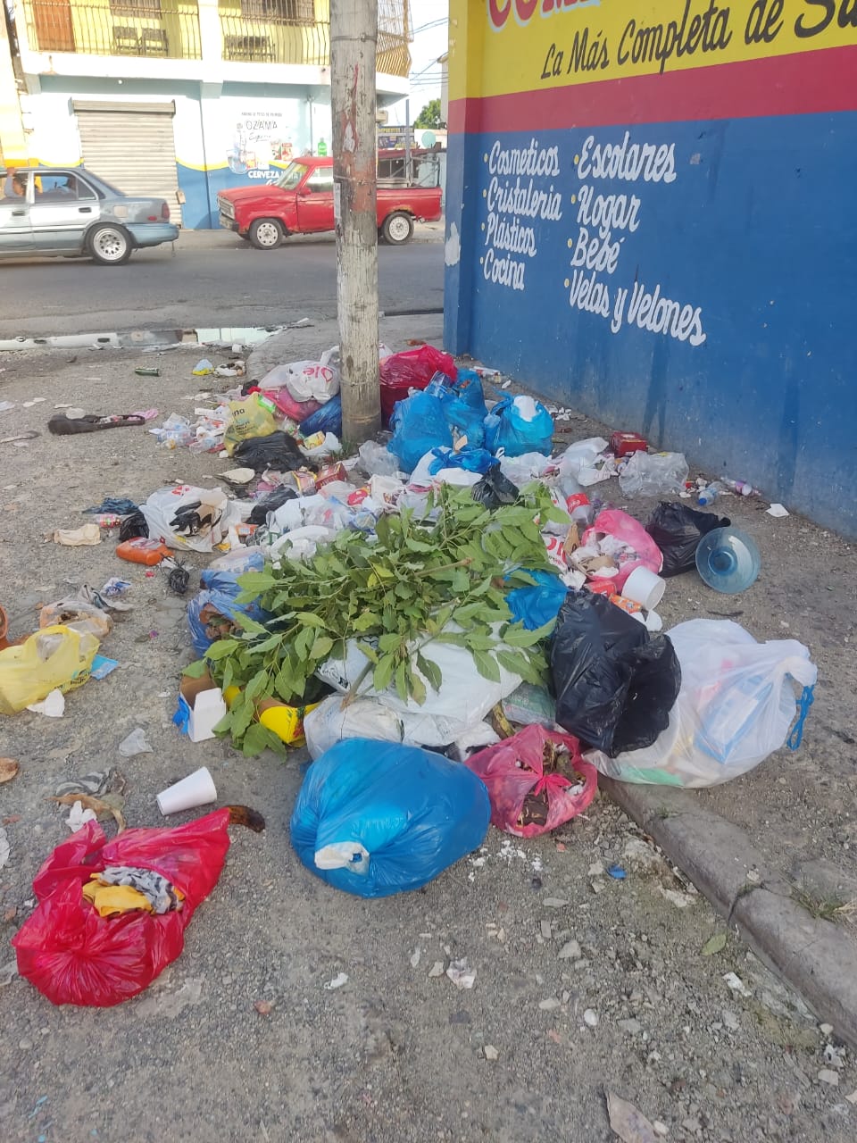 Basura acumulada en la calle junto a una tienda.