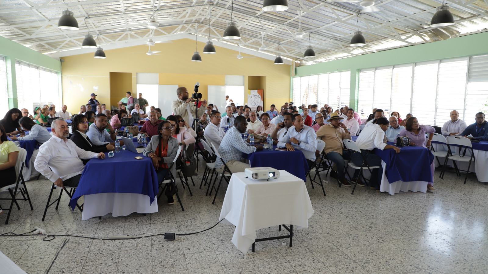 Personas reunidas en un evento en interior amplio.