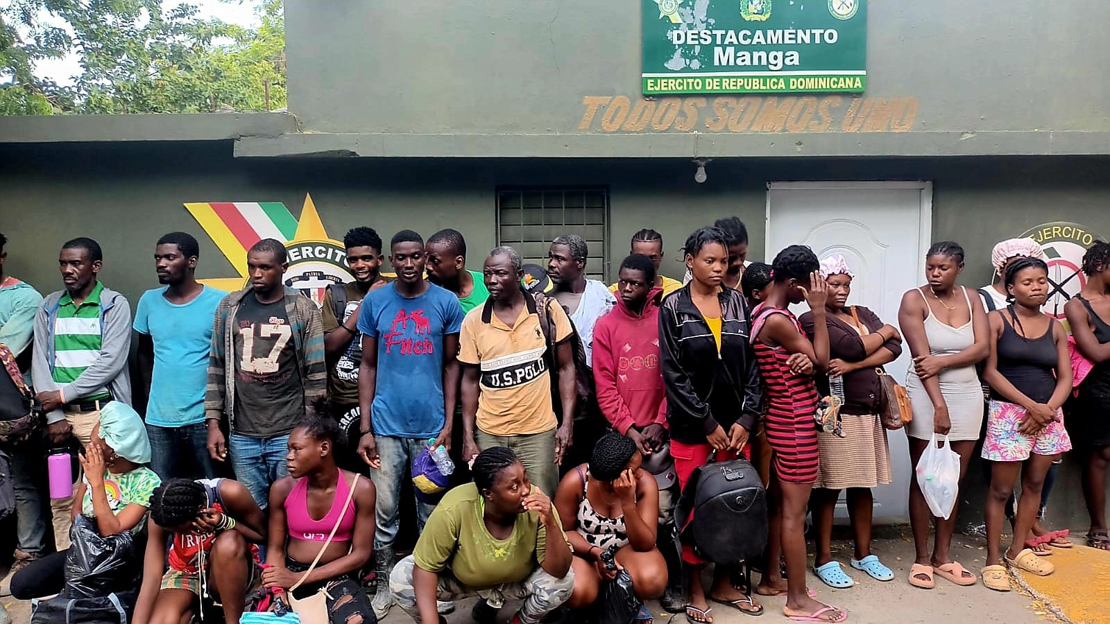 Grupo de personas frente a destacamento militar.