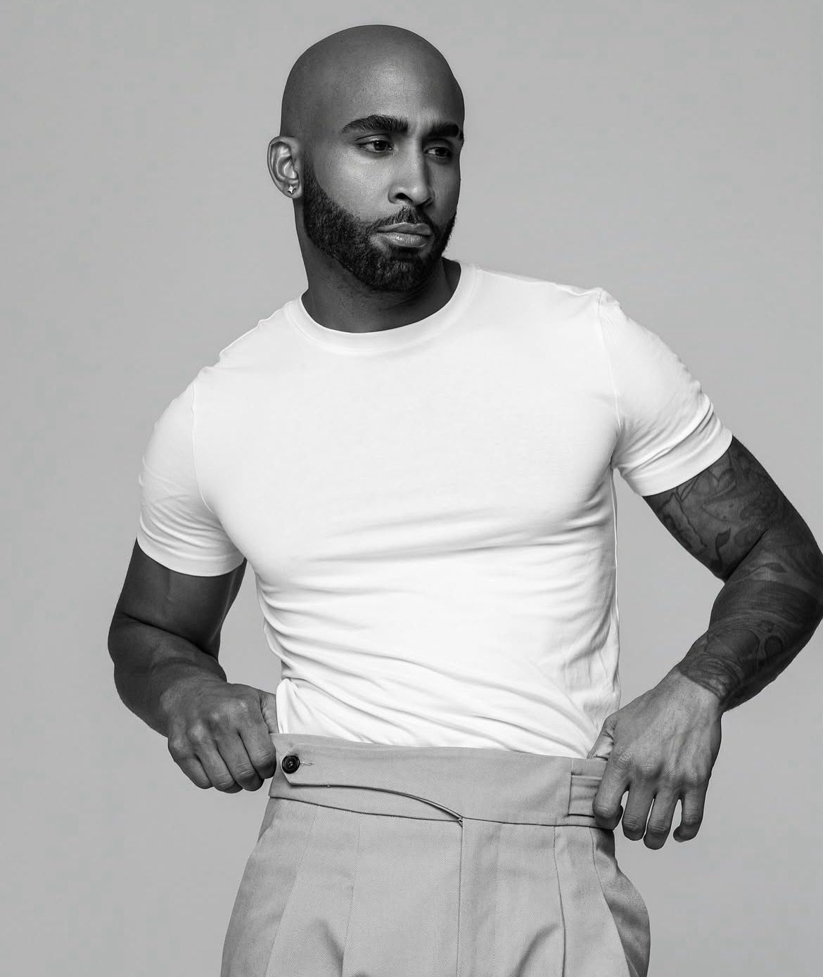 Hombre con camiseta blanca y pantalones claros.