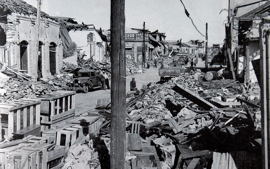 Destrucción urbana por terremoto, escombros y edificios dañados.