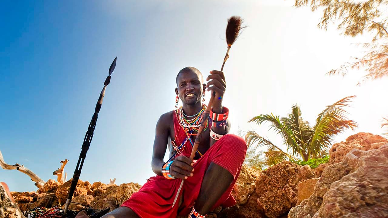 Hombre local con lanza y brazaletes coloridos.