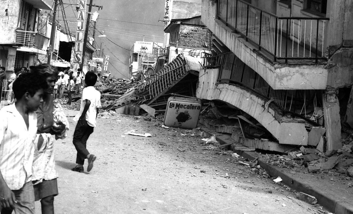Edificio colapsado después de un terremoto, personas caminando