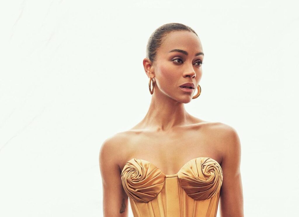 Mujer con vestido dorado elegante y pendientes grandes.
